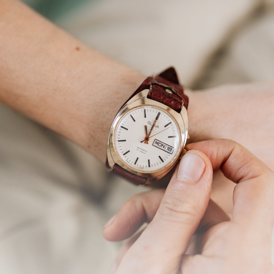 Rose gold watch with brown leather strap on a wrist